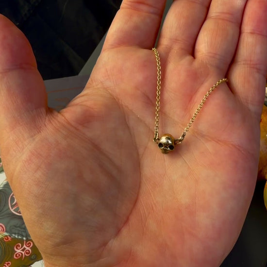 A handmade 9ct gold skull forward necklace by Virginia Allan — luxury dark gold jewellery hallmarked in Hastings