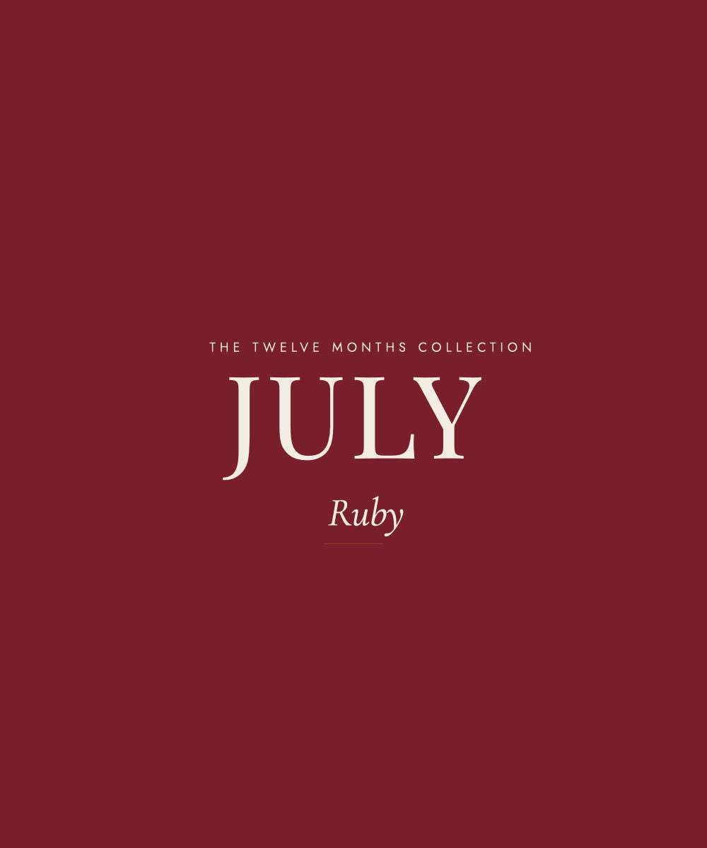 A minimalist graphic with a solid deep ruby-red background and centered cream text reading 'THE TWELVE MONTHS COLLECTION', 'JULY', and 'Ruby'.
